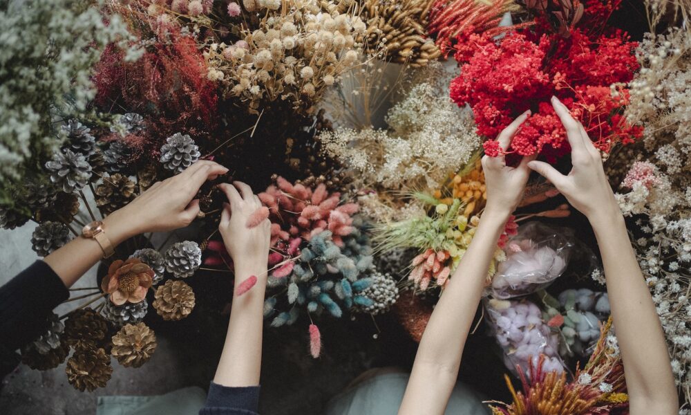 dried succulent parts - Top view of crop unrecognizable women standing near table and choosing dried flowers during workshop in daytime