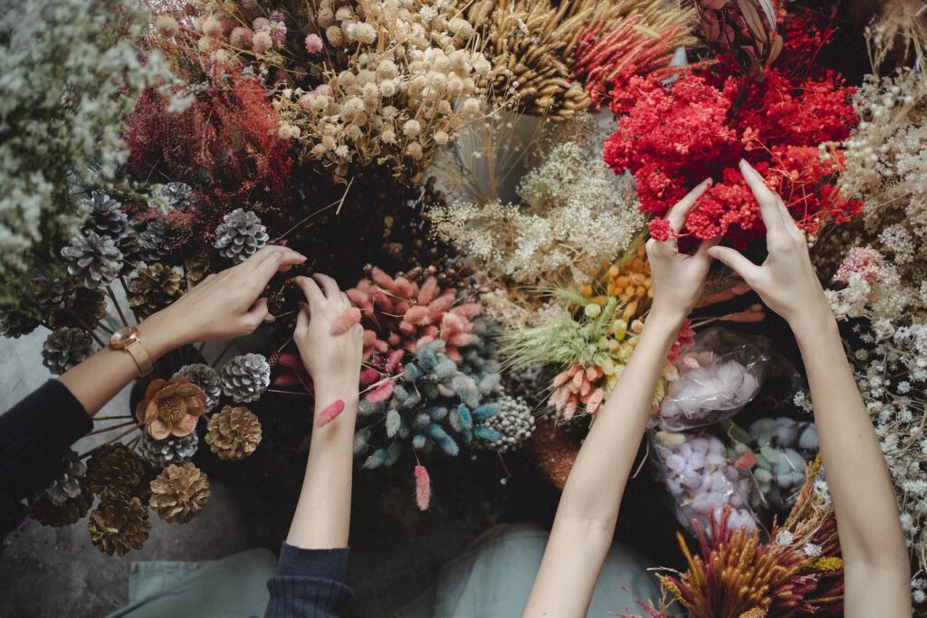 dried succulent parts - Top view of crop unrecognizable women standing near table and choosing dried flowers during workshop in daytime